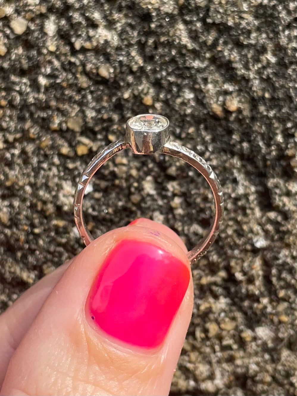 Hand holding white sapphire and silver ring hand crafted in Sri Lanka size 7