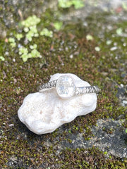 Silver and white sapphire ring on beautiful engraved band sitting on a rock in Sri Lanka 