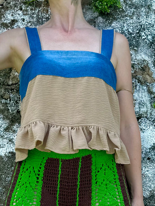 Person wearing a blue top and beige ruffled tank top with a green and brown patterned mat - The Retro Baby Doll Top - Upcycled Denim & Pants 