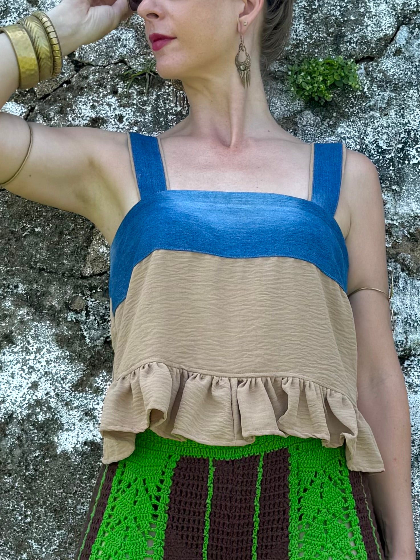 Woman wearing Retro Baby Doll Top made from upcycled denim jeans and khaki pants leaning on a wall in Sri Lanka