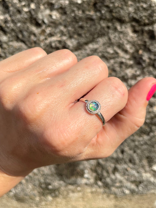 Hand wearing a Sri Lankan Opal & silver dainty ring, genuine silver and opal made by local artisan. 