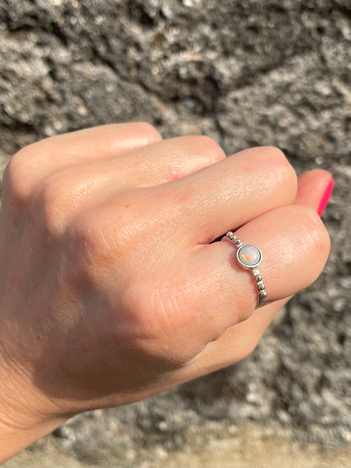 Hand wearing opal and textured silver ring made in Sri Lanka by local artisans